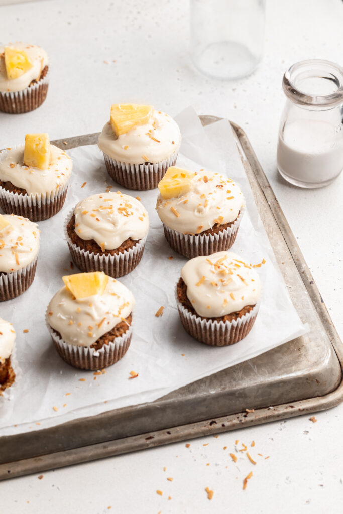 almond flour hummingbird cupcakes on a baking sheet with almond milk on the side.