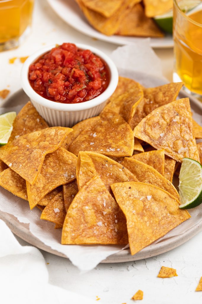 Gluten-Free baked tortilla chips with a side of salsa and beer.
