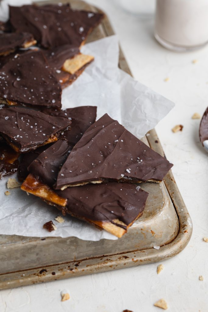 christmas crack pieces on a baking sheet with milk on the side