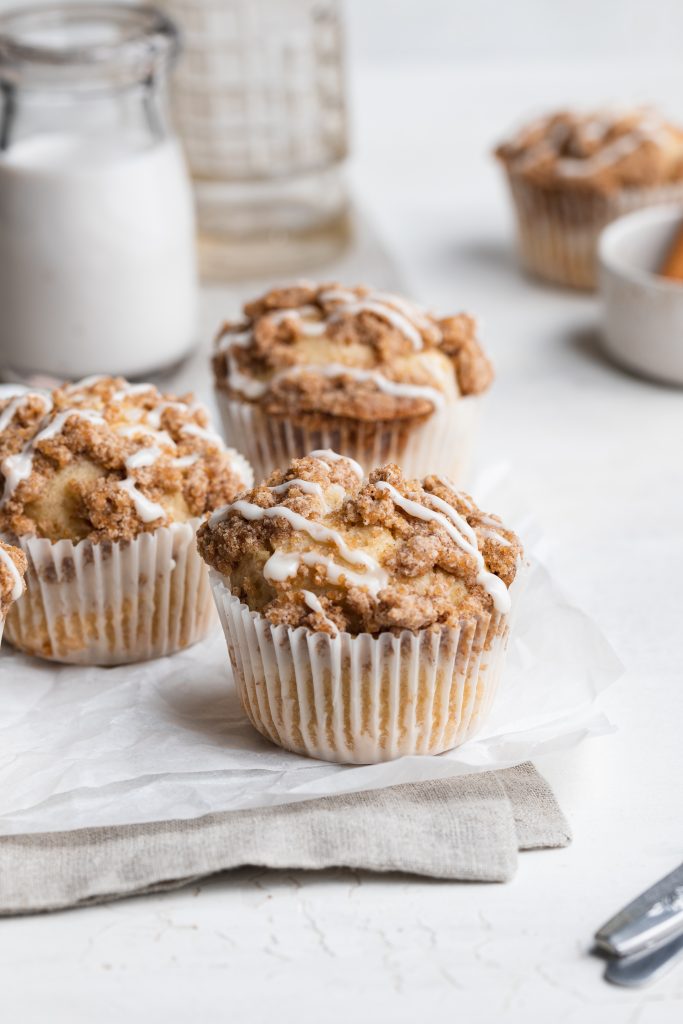gluten-free coffee cake muffins on parchment paper with milk on the side