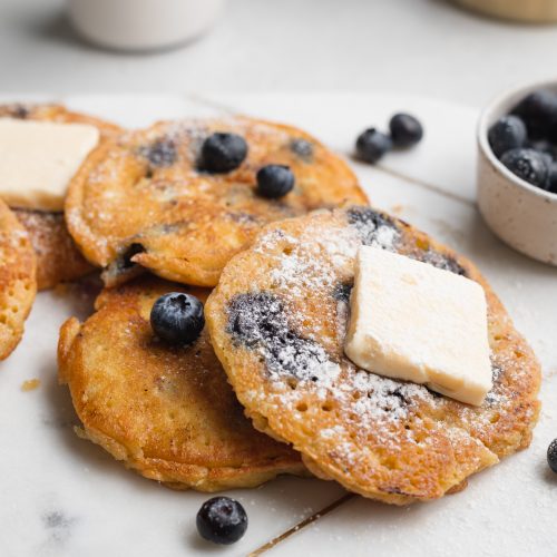 almond flour pancakes with blueberries on a marble board