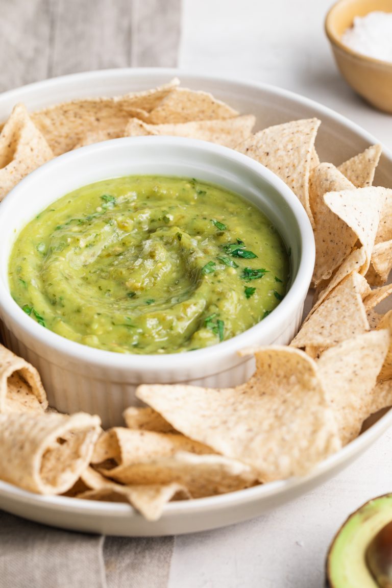 close-up image of guacamole salsa with chips on the side