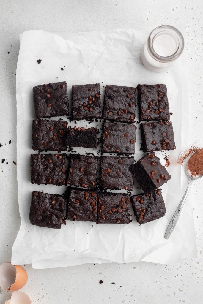 overhead image of paleo brownies with milk and cocoa powder on the side