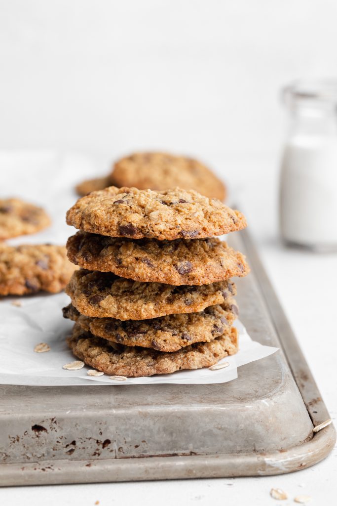 a stack of gluten-free oatmeal cookies on an upside down cookie sheet.