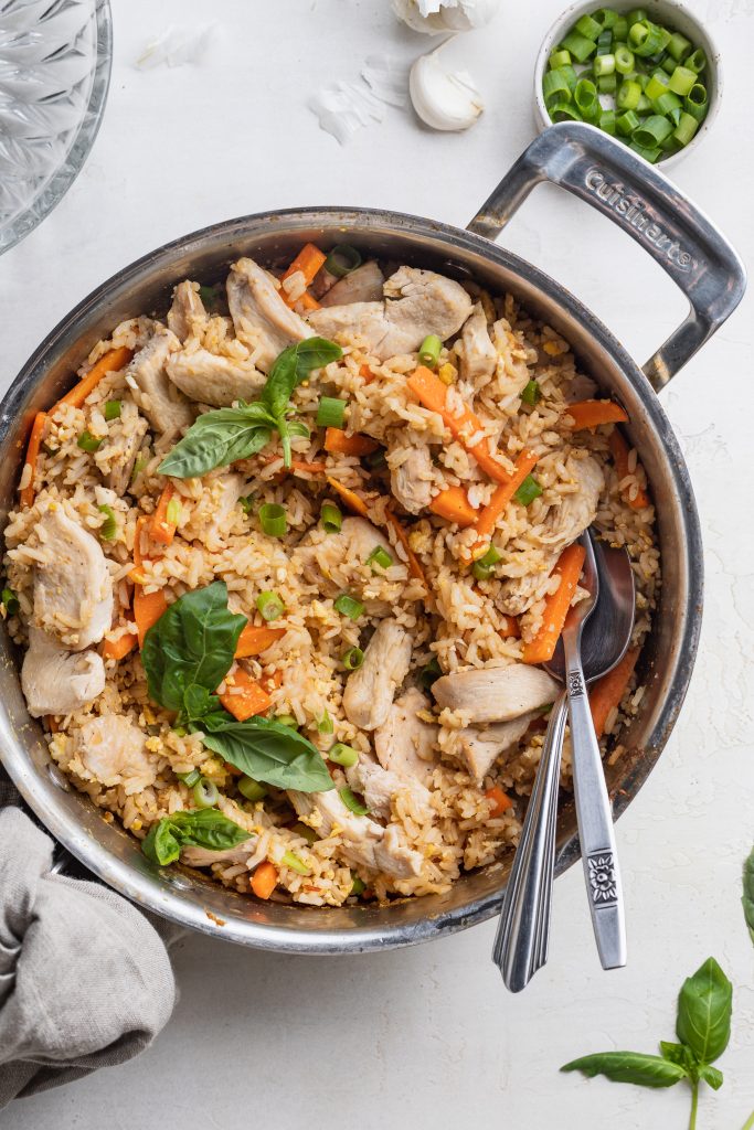 Thai fried rice in a pan with fresh thai basil on top