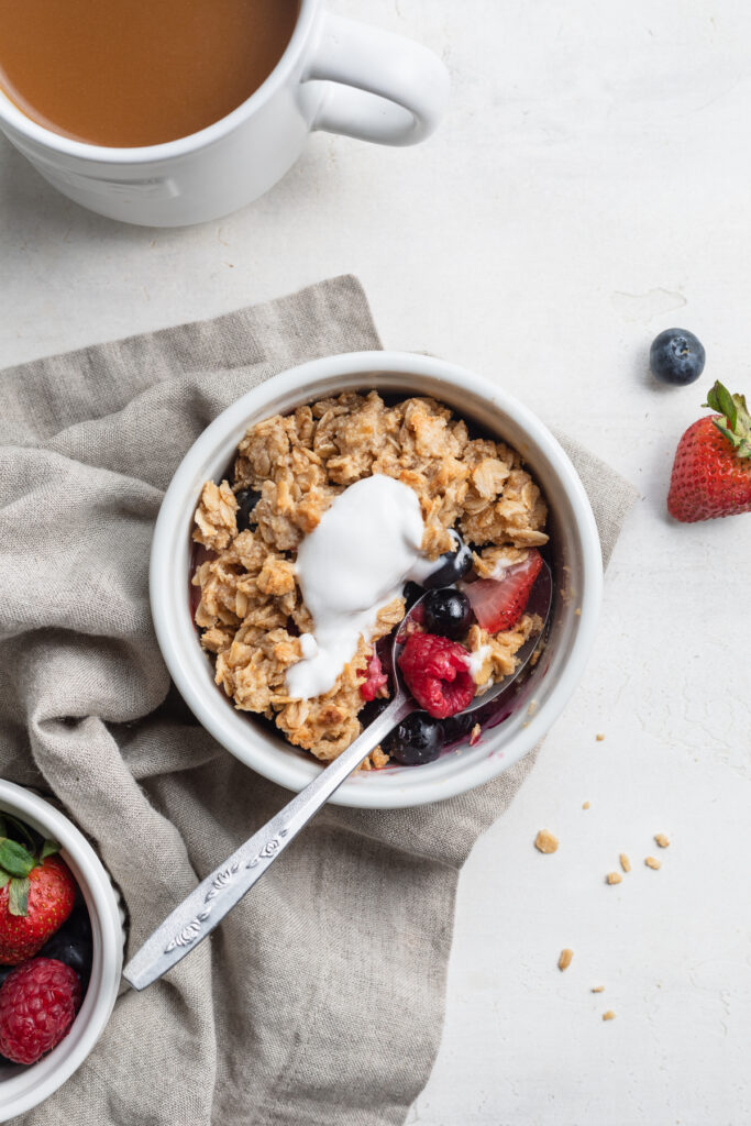 overhead image of berry breakfast crisp with coconut yogurt on top.