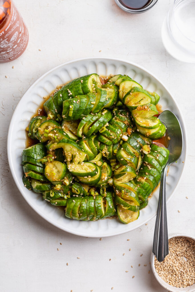overhead image of asian cucumber salad on a plate with a spoon