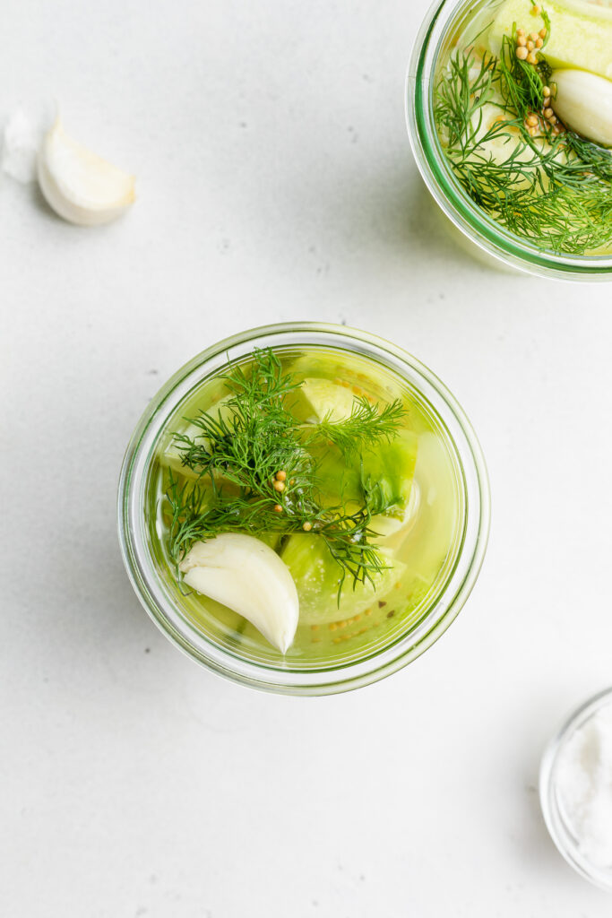 overhead image of pickles with garlic and fresh dill.