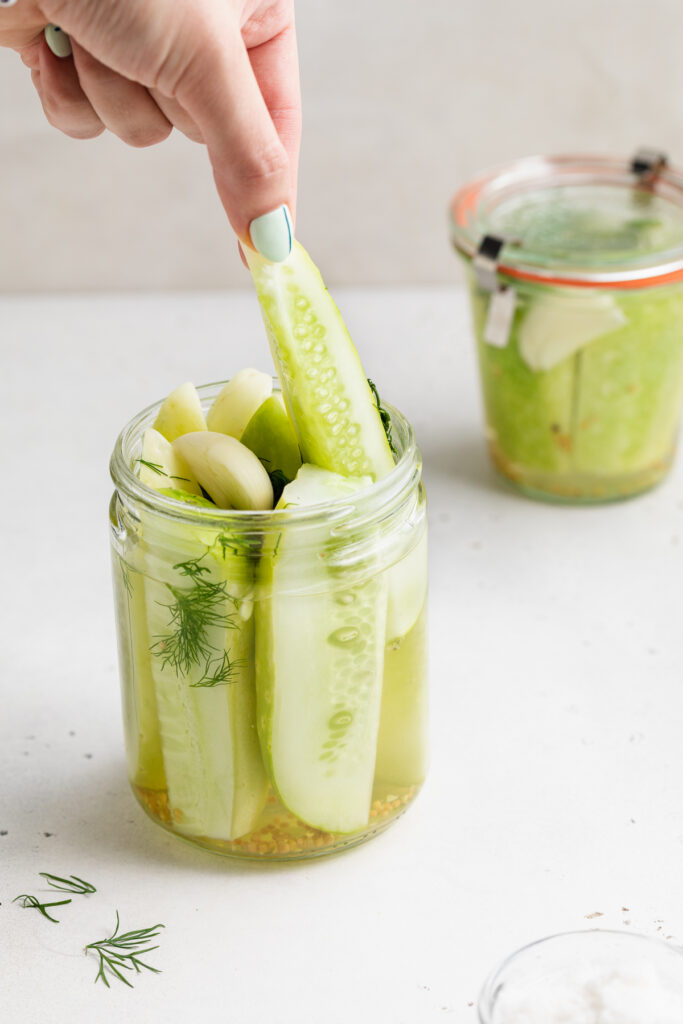 a pickle being lifted out of a jar of pickles.