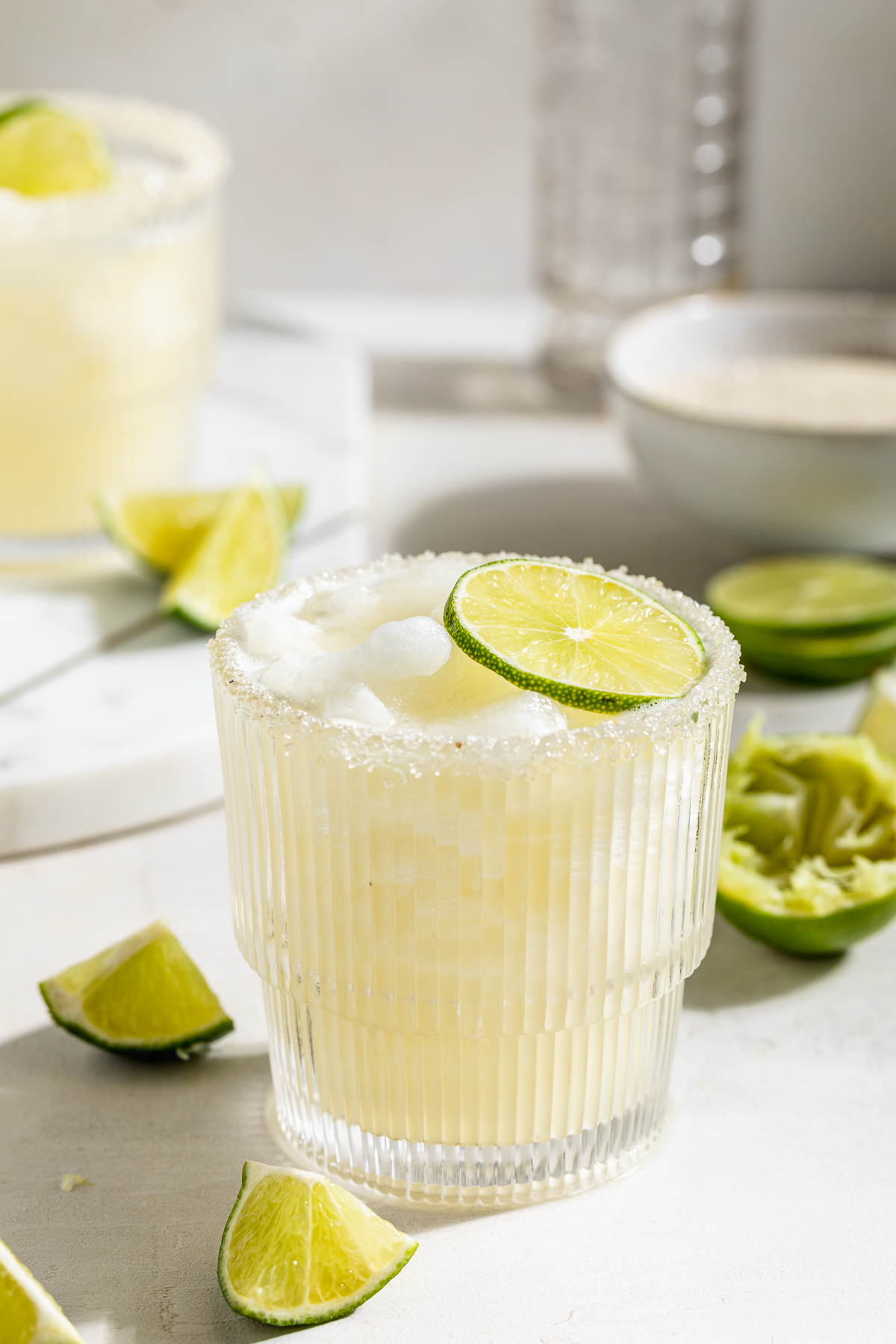frozen daiquiri with fresh limes on the side.