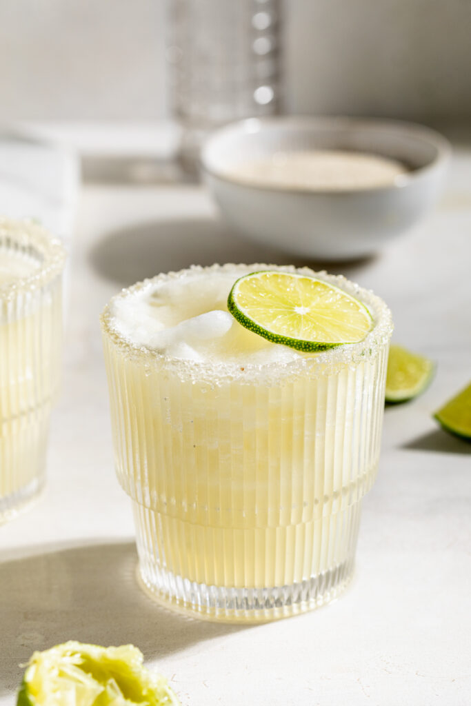 closeup image of a frozen daiquiri with limes on the side.