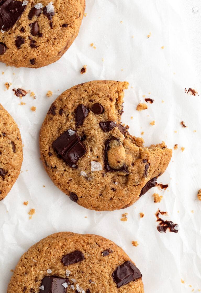overhead image of an almond flour chocolate chip cookie with a bite taken out.