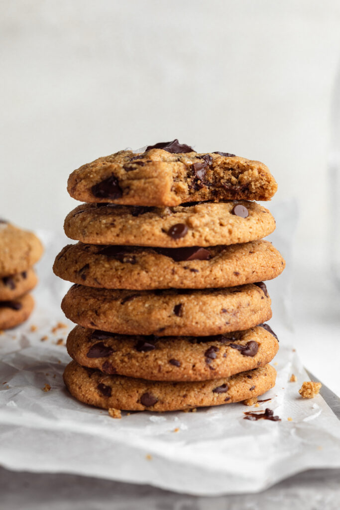 Close-up of a stack of gluten-free almond flour chocolate chip cookies with a bite taken out of the first cookie.
