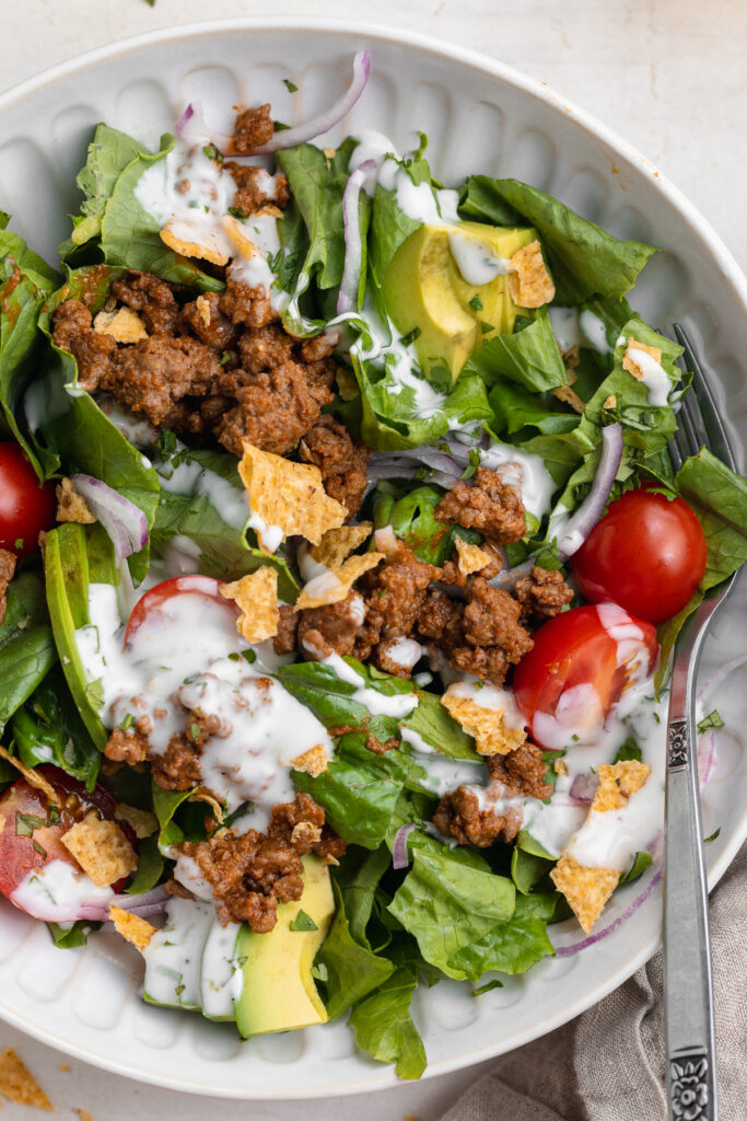 overhead close-up image of a taco salad with cilantro-lime dressing on top.