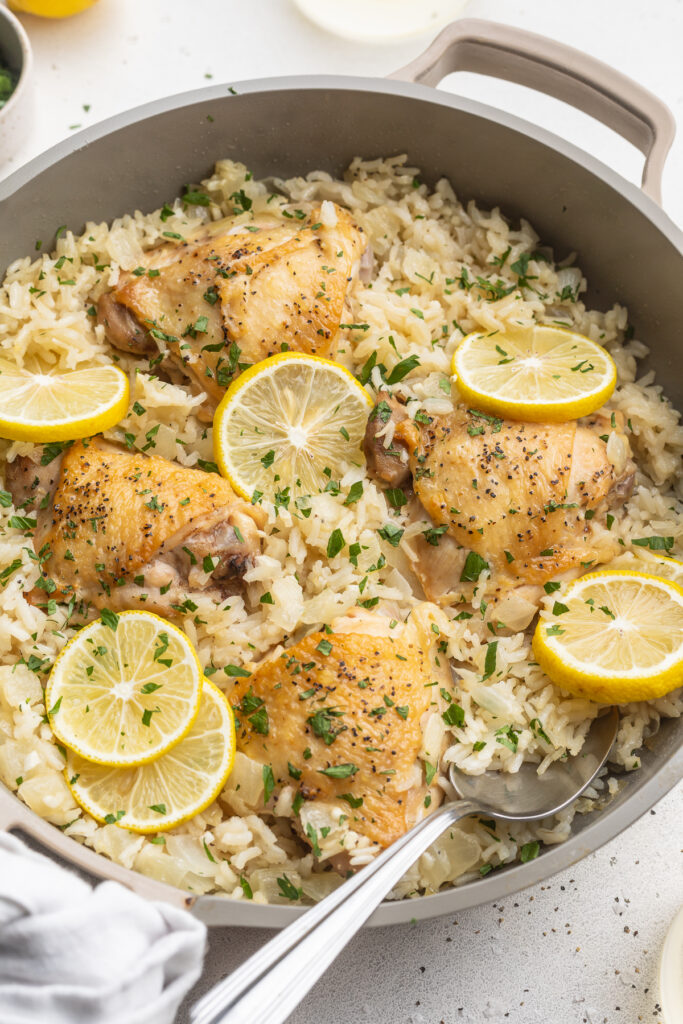 chicken and rice in a pan with a serving spoon.