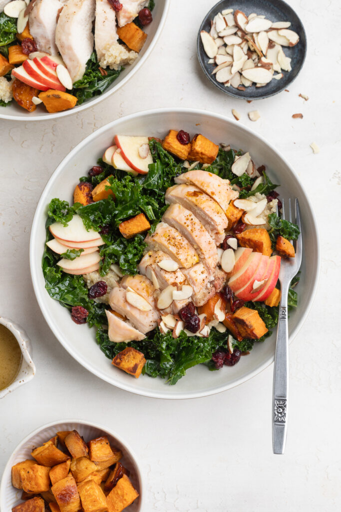 overhead image of a meal prep harvest bowl with sliced almonds on the side.