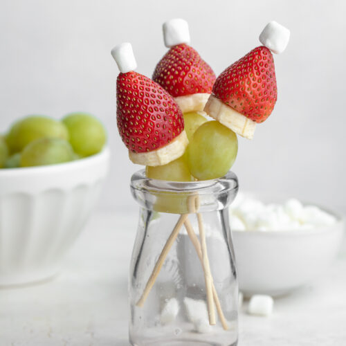 grinch fruit kabobs in a glass, standing upright