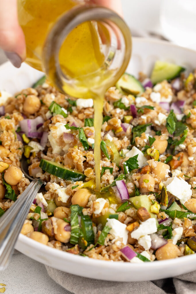 Dressing being poured over the Jennifer Aniston salad.