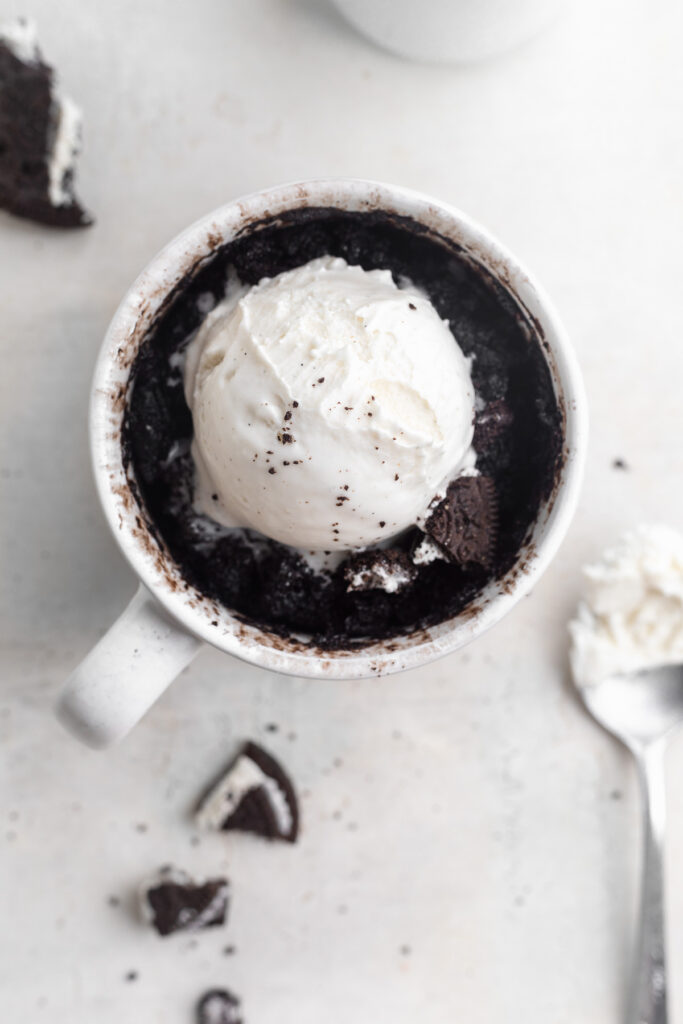 overhead image of oreo mug cake with vanilla ice cream on top and milk on the side.