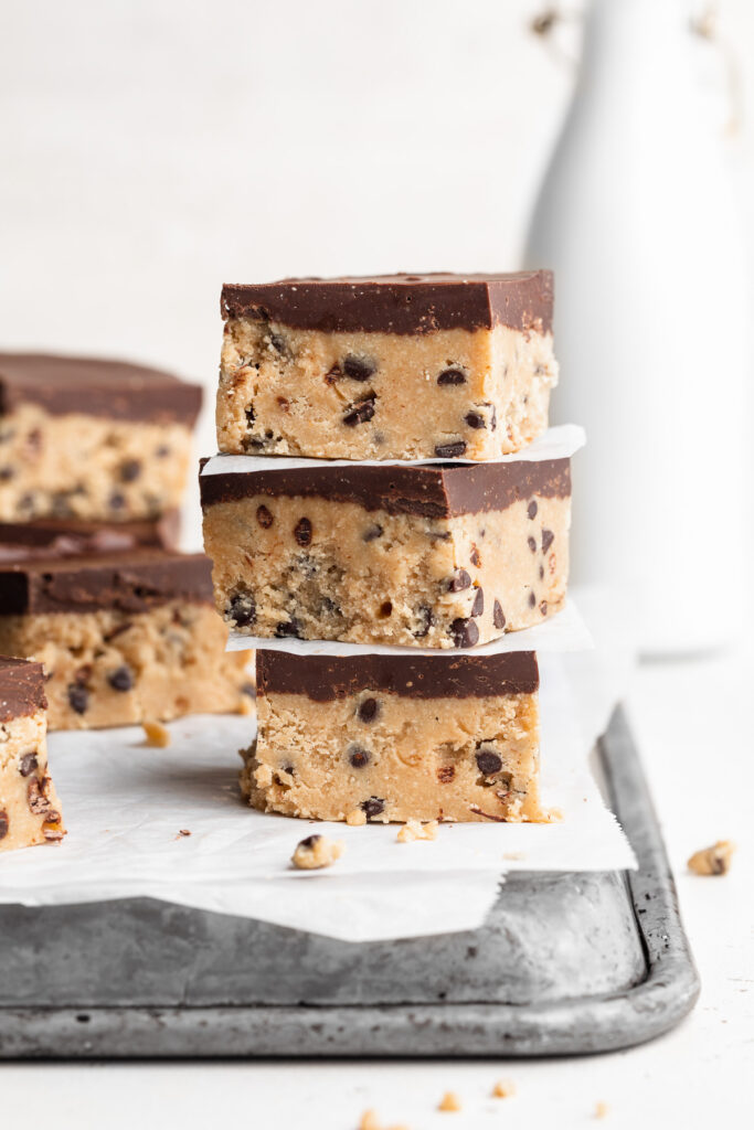 three healthy no bake cookie dough bars stacked on top of each other.