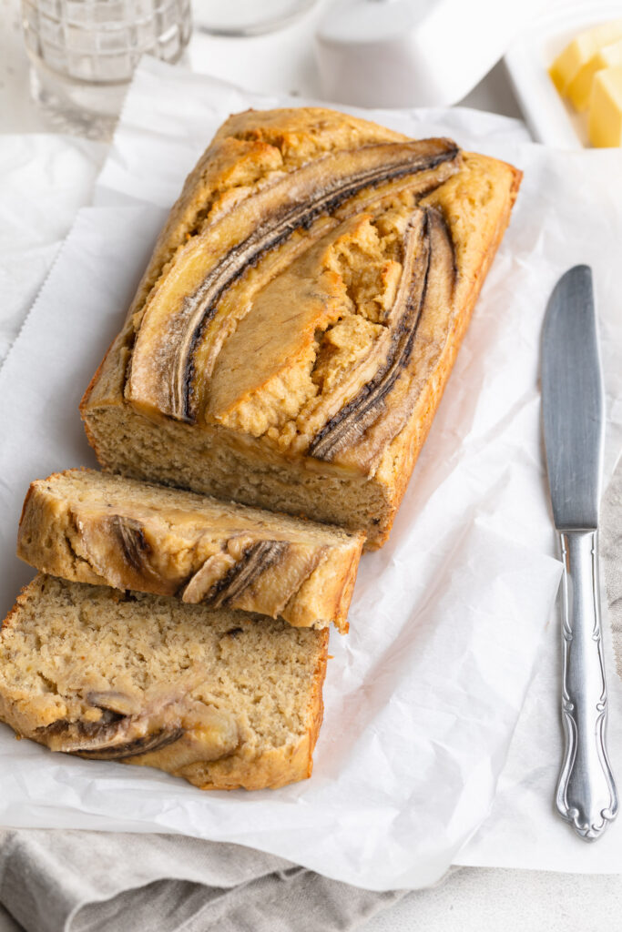 sliced 4 ingredient banana bread with a knife on the side.