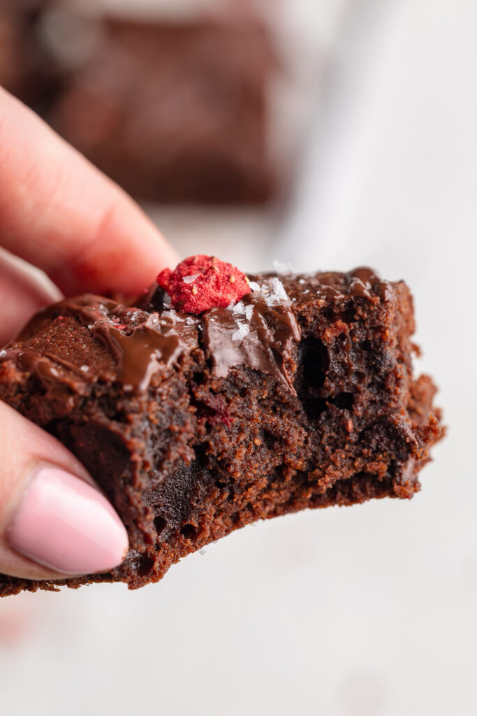bite shot of chocolate covered strawberry almond flour brownies.
