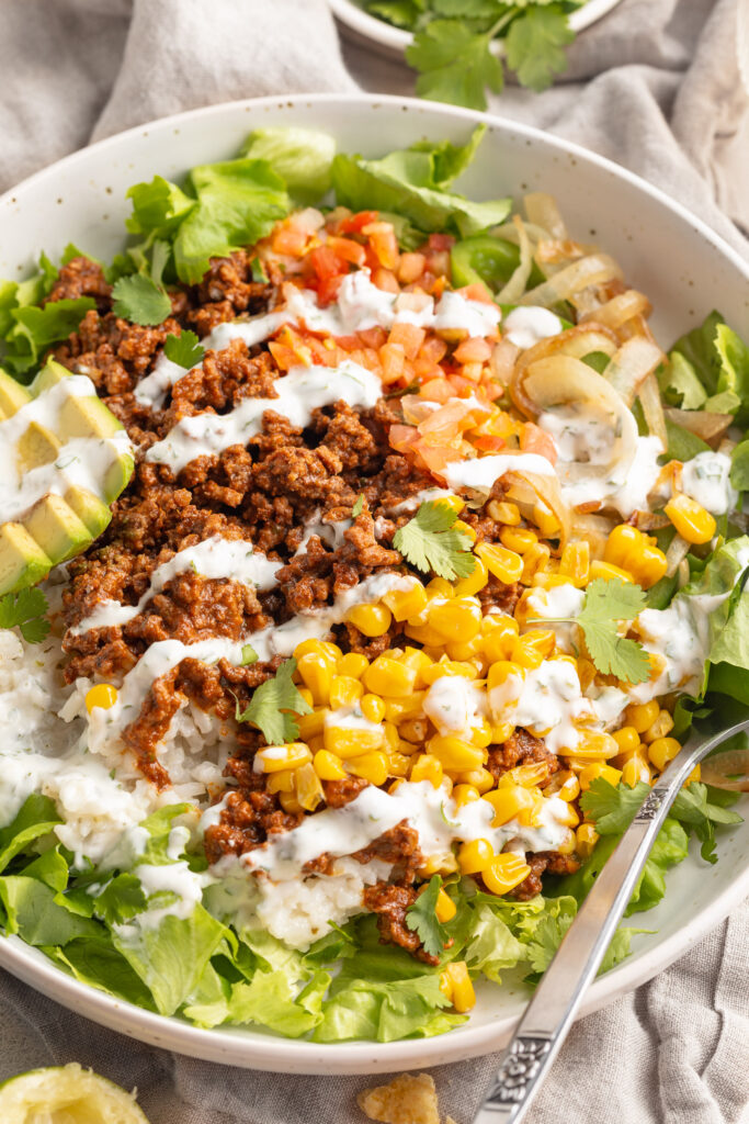 taco bowls with cilantro lime crema on top and chips on the side.