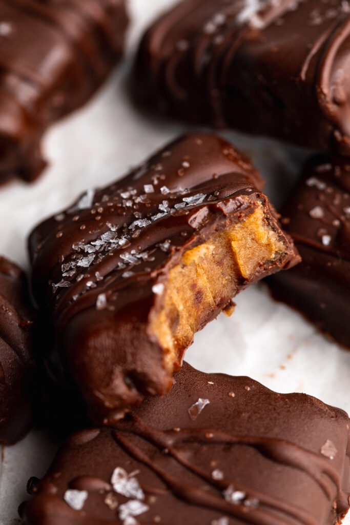 close up image of a date caramel candy with a bite taken out.