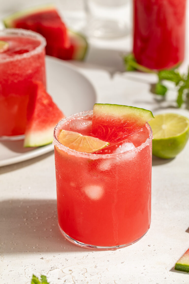 watermelon paloma in a glass with a lime slice and a small slice of watermelon.