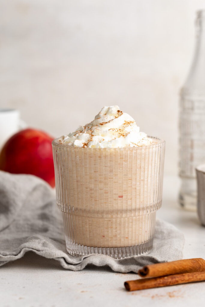 apple pie smoothie in a glass with whipped cream.