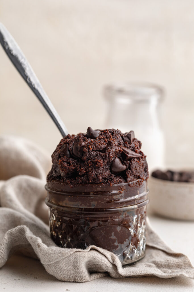 healthy edible brownie batter in a jar on a tea towel.