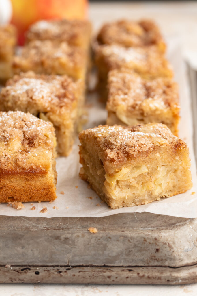 gluten-free cinnamon sugar apple cake sliced into squares on a baking sheet.