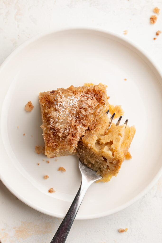 gluten-free cinnamon sugar apple cake slice on a small dish with a fork.