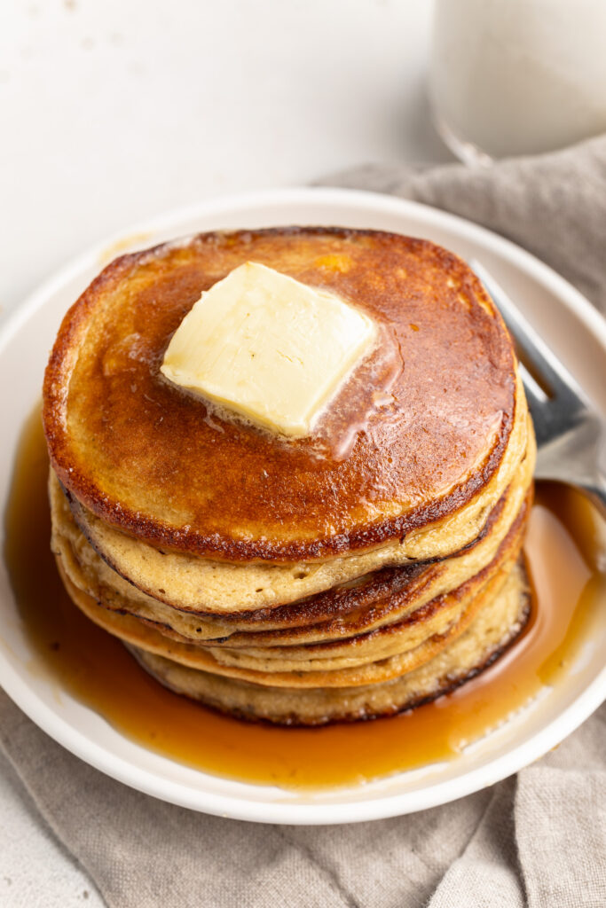 3 ingredient protein pancakes on a plate with butter and maple syrup.