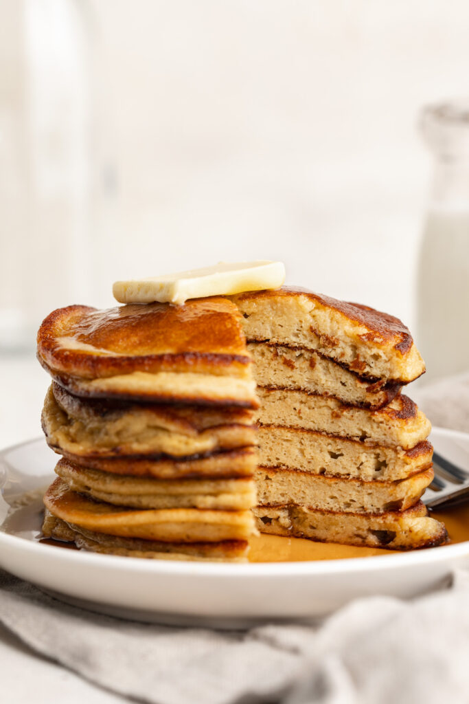 3 ingredient protein pancakes stacked on a plate and cut into.