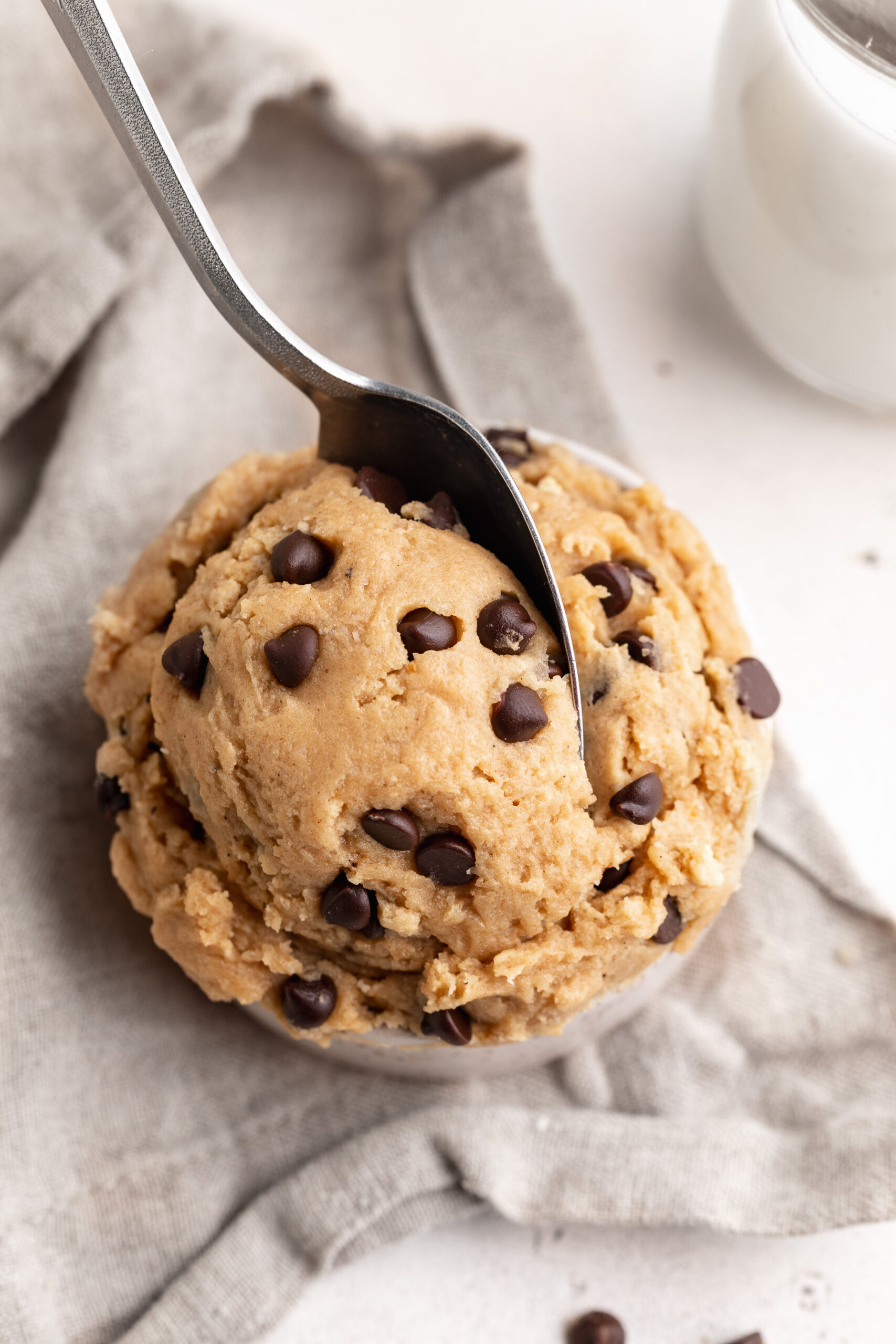 5 ingredient edible protein chocolate chip cookie dough in a small cup with a spoon.