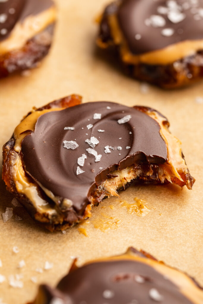 a bite taken out of a smashed date with peanut butter and chocolate.
