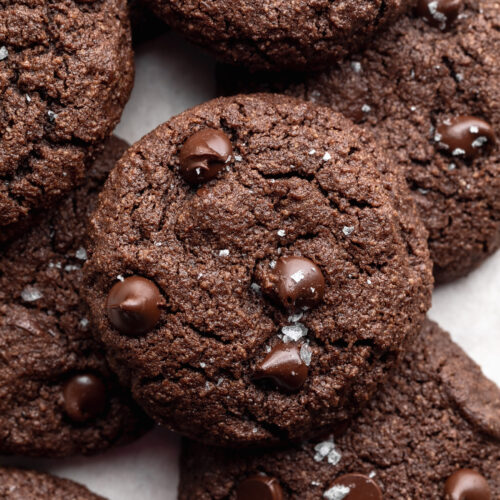 almond flour chocolate cookies on top of each other of a baking sheet.