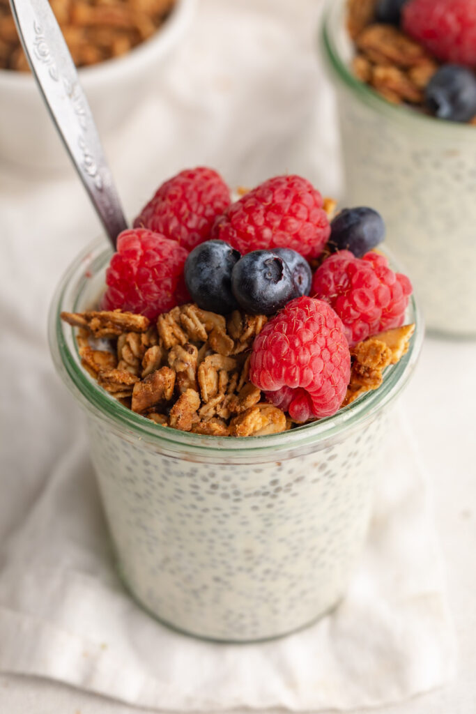 overhead image of chia seed protein pudding with granola and fresh berries on top.