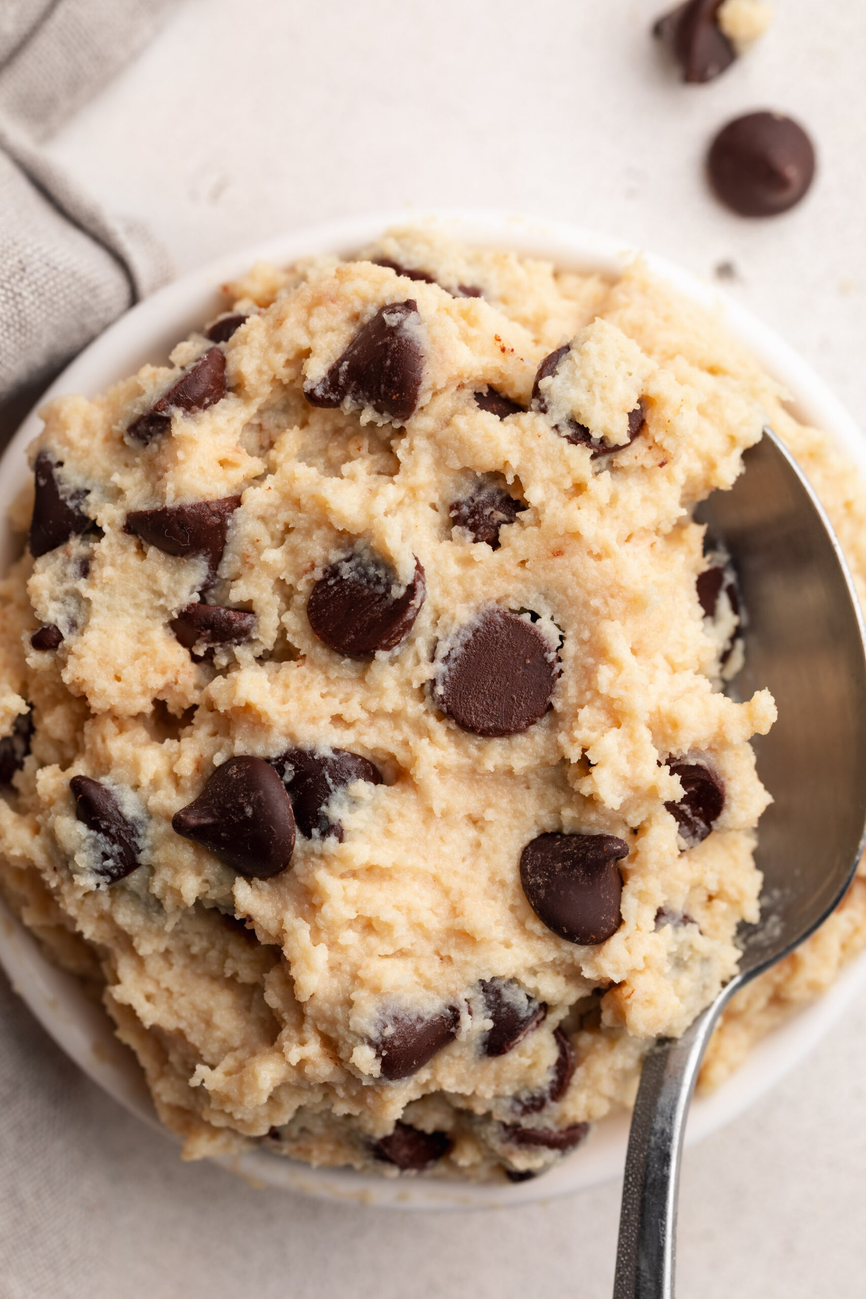 overhead image of chocolate chip cottage cheese cookie dough in a dish with a spoon.