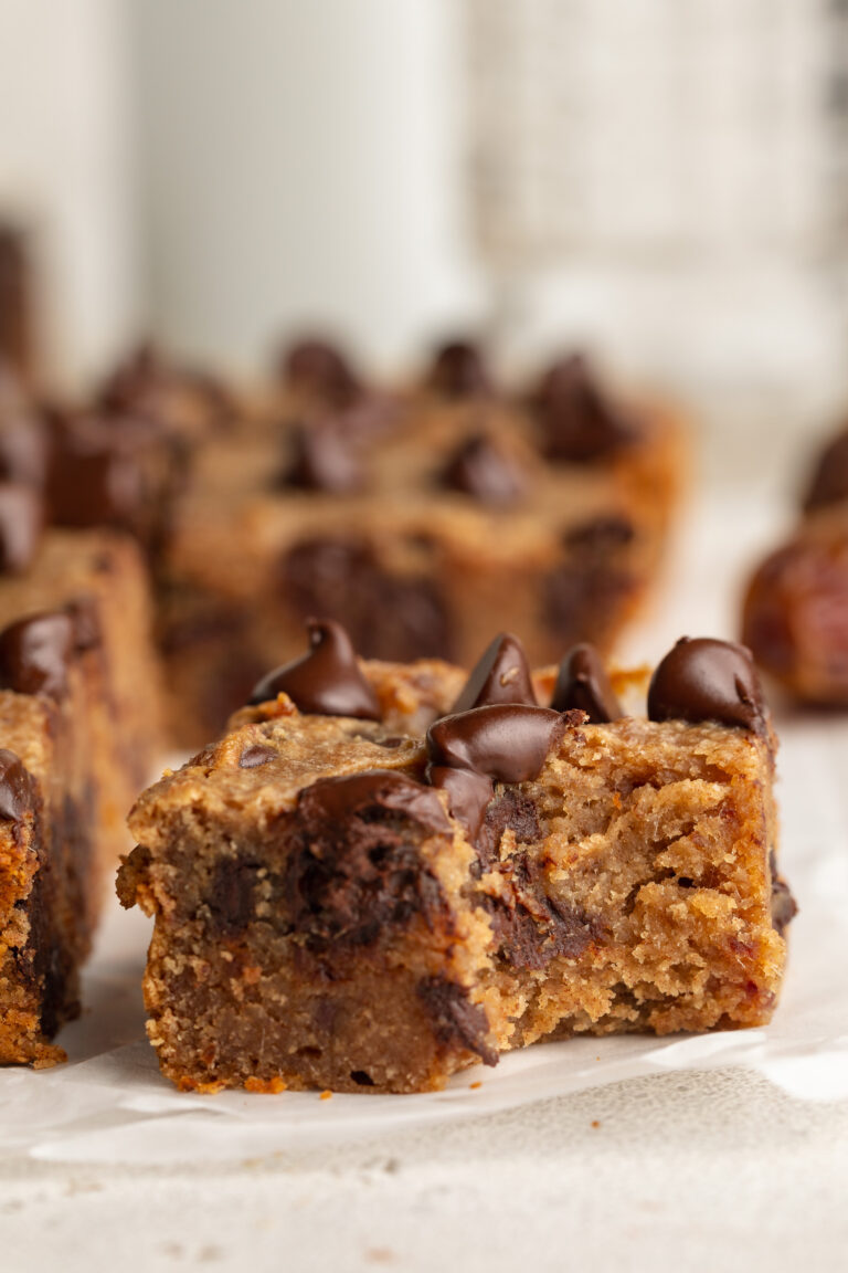 a slice of chocolate chip date cake with a bite taken out.