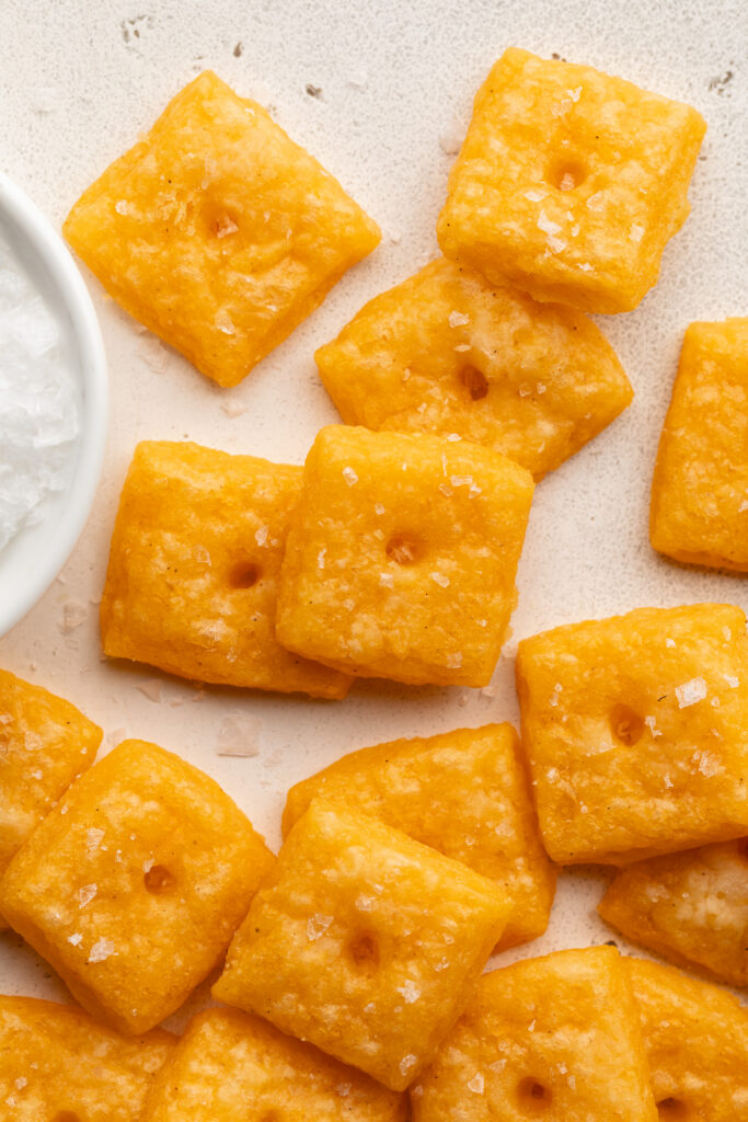 gluten free cheez its on a table with flaky sea salt.