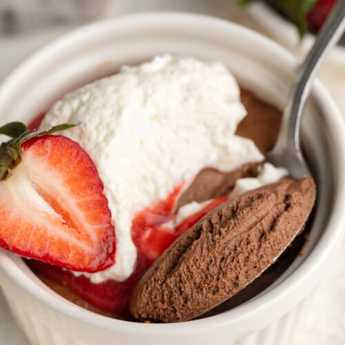 close up image of 3 ingredient healthy chocolate mousse in a ramekin with a spoon.