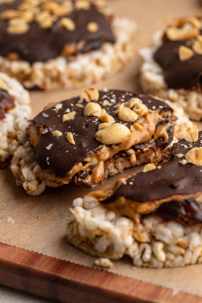 healthy snickers rice cakes with chopped peanuts on top.