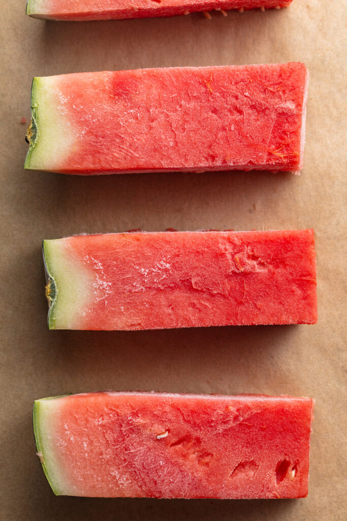 frozen watermelon spears on a baking sheet.