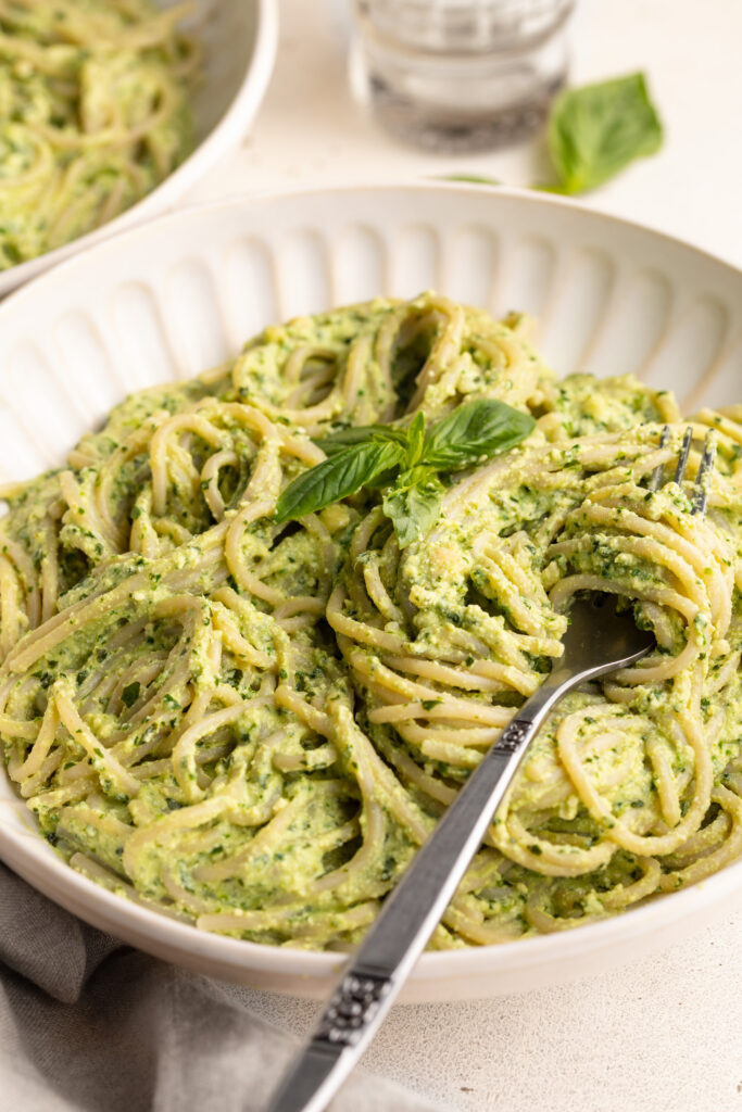 high protein pesto pasta in a bowl with a fork.