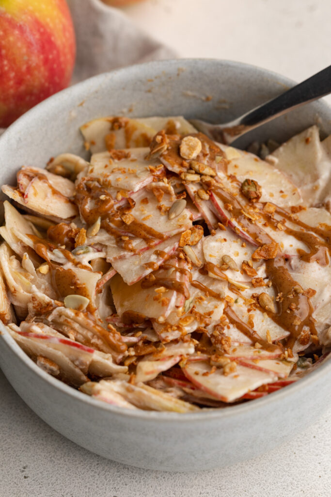 healthy high protein apple pie salad in a bowl with a fork.