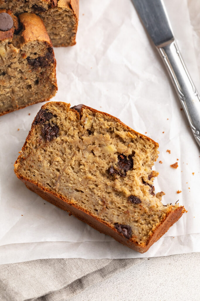 a slice of protein banana bread with a bite taken out.