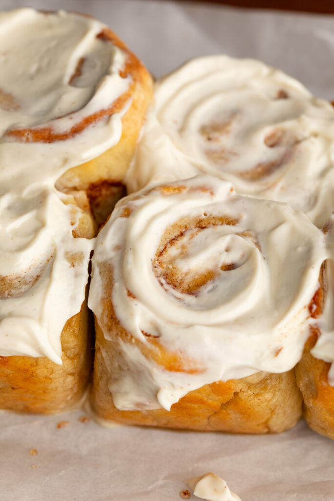 protein cinnamon rolls with greek yogurt cream cheese frosting on top.