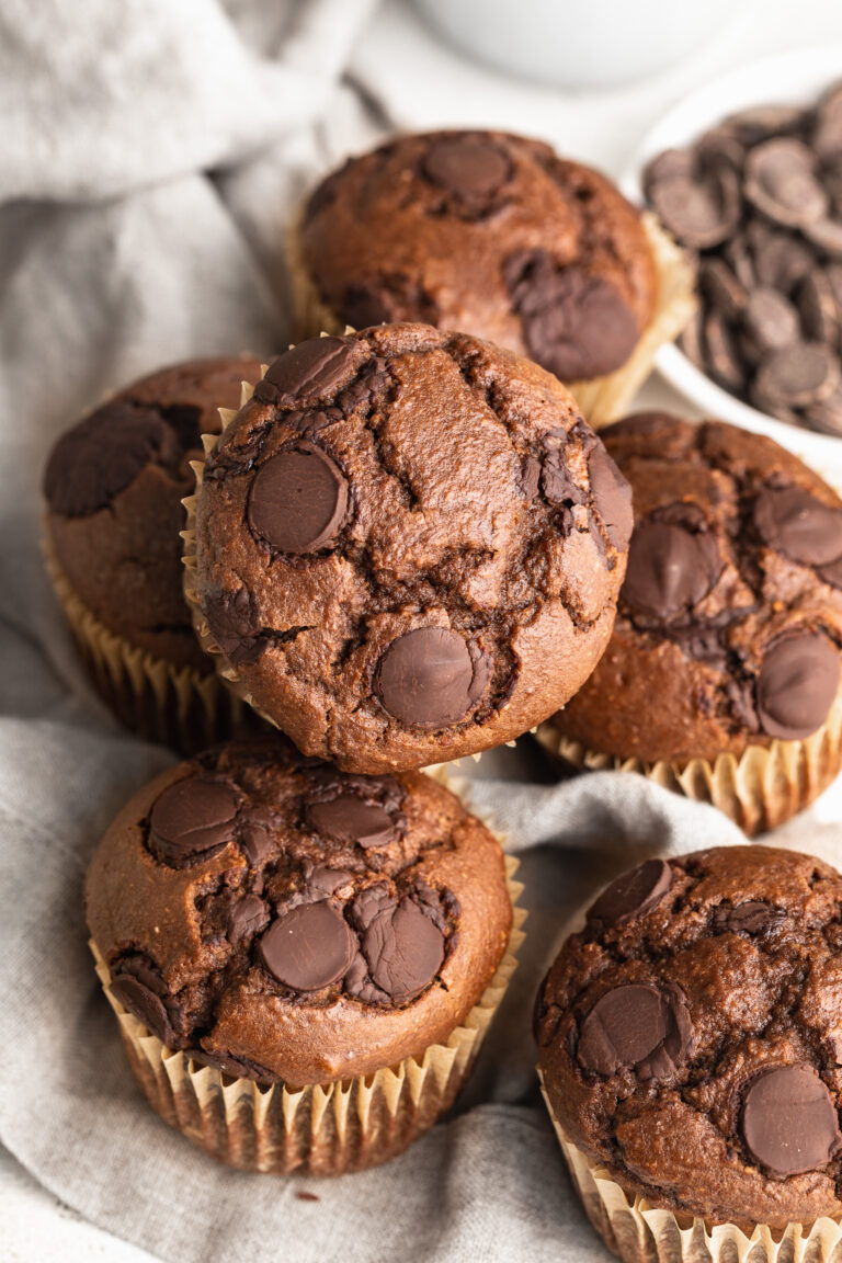double chocolate protein muffins stacked on a table.